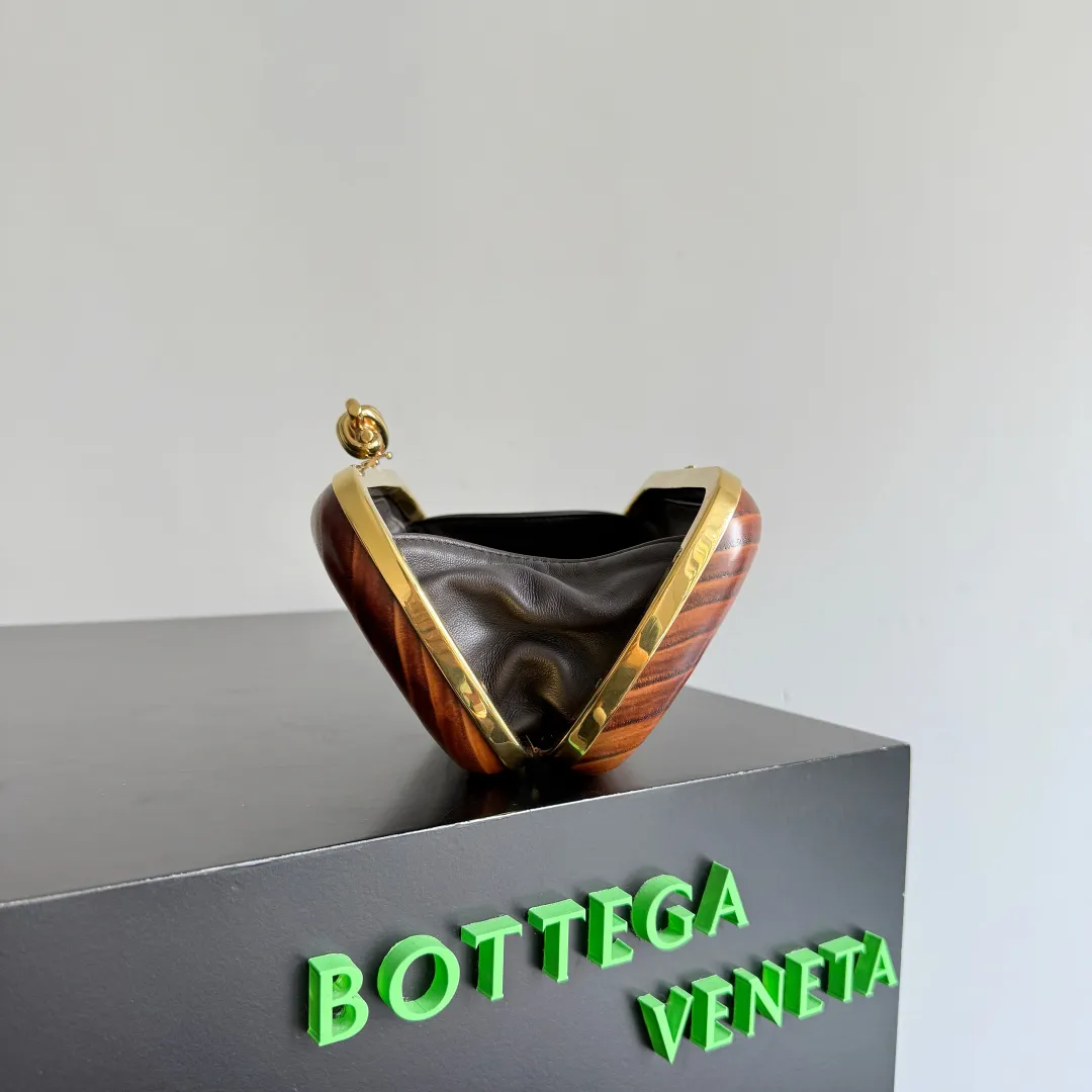 Batch 2720 BOTTEGA VENETA2025 new kont evening bag When the natural texture of wood meets the brass edge, the BV evening bag becomes a work of art in the fashion world. Every wood grain is a mark of time, delicate and unique. The brass metal buckle is embellished like stars, and opening it is full of ritual. It is the focus of the dinner party, and can easily store your exquisite small things. The warmth of wood and the cold and cool collision of metal tell the niche light luxury style in every gesture, allowing you to shine with a unique attitude in every feast. Style number: 804292 (717622) Color: maroon Size: 20.5*6*12.5cm